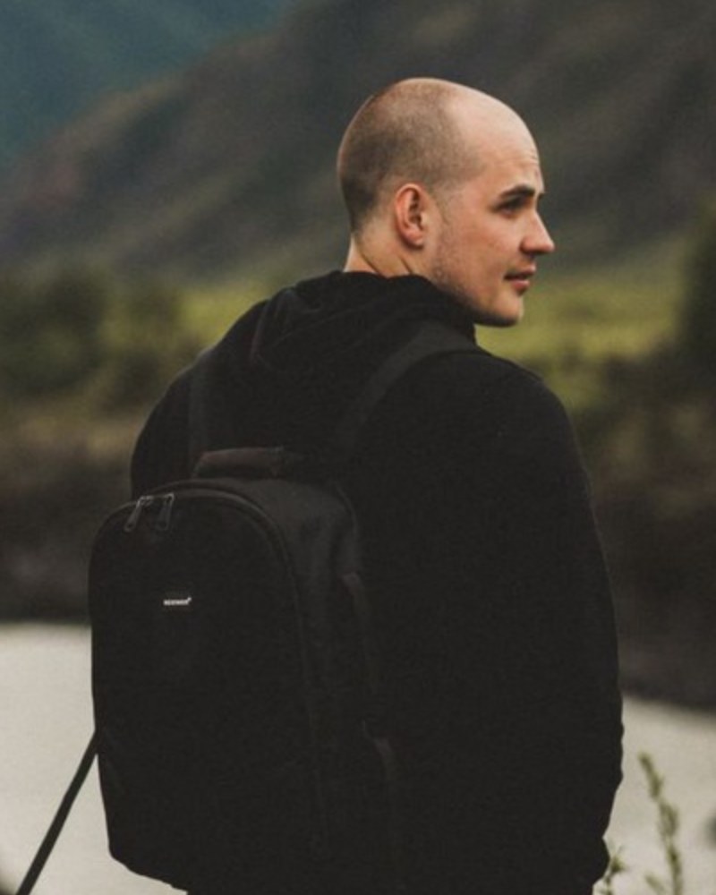 Nick Maslov, standing above a river in the mountains